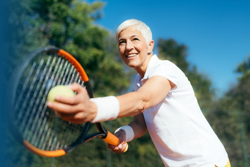 Close up of senior with tennis racket