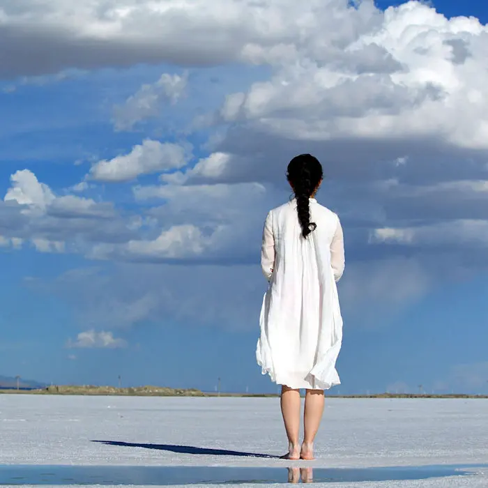 Woman on beach under blue skies